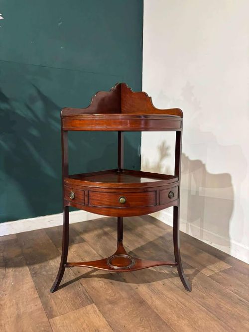 fig 8. A Georgian mahogany corner washstand featuring a tiered design with a shaped splashback, central bowfront drawer, and curved lower stretcher.