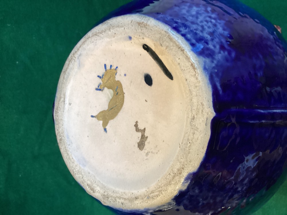 A Victorian majolica earthenware jug featuring a vibrant cobalt blue body adorned with relief-moulded green leaves, pink blossoms, and a faux-twining wood handle. View VI