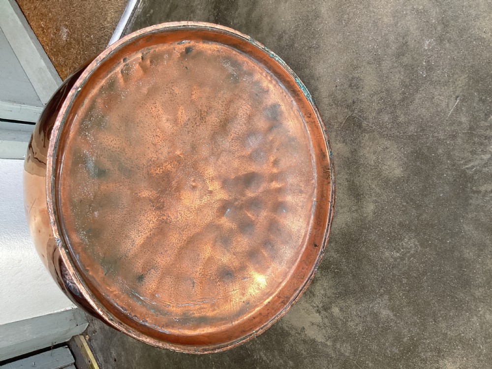A large Victorian polished copper ale jug with a wide bulbous body, flared neck, stamped verification mark, and robust strap handle. View V
