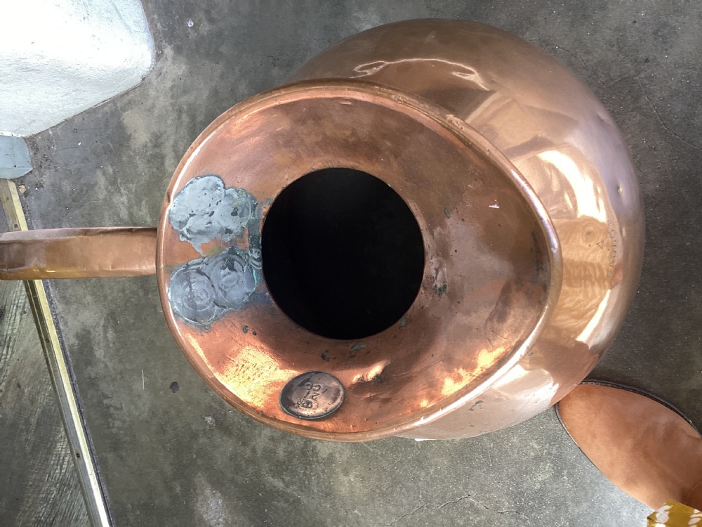 A large Victorian polished copper ale jug with a wide bulbous body, flared neck, stamped verification mark, and robust strap handle. View VI
