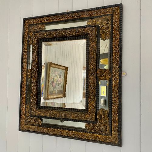 A Repousse Brass and Ebonised Cushion Mirror