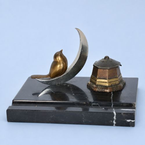 fig 1. An Art Deco black marble desk tidy featuring a bronze bird perched on a silver-coloured crescent moon beside an octagonal metal inkwell.