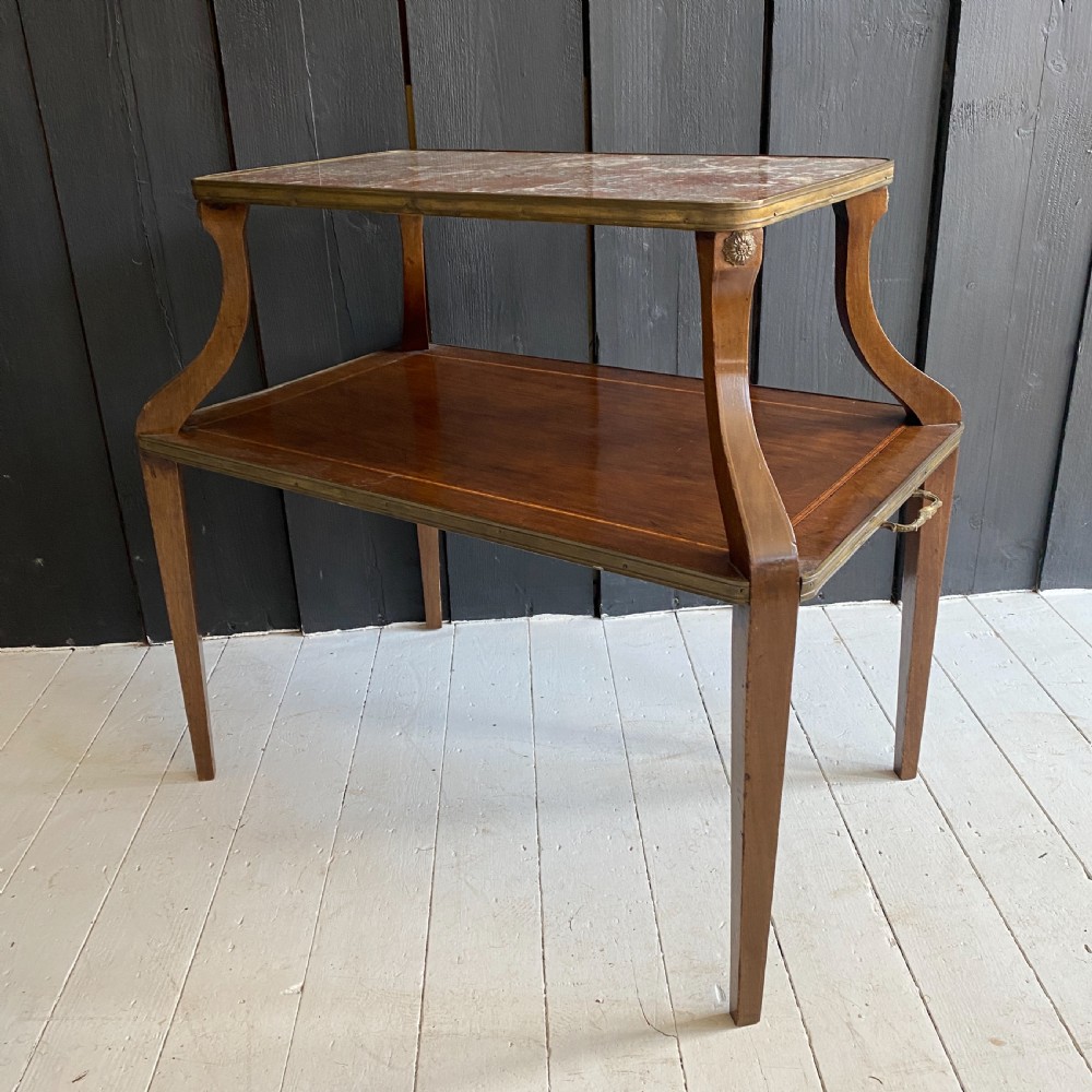 A two-tiered mahogany side table featuring a pink-veined marble top framed in brass, supported by curved legs over a lower wood shelf with brass side handles. View II