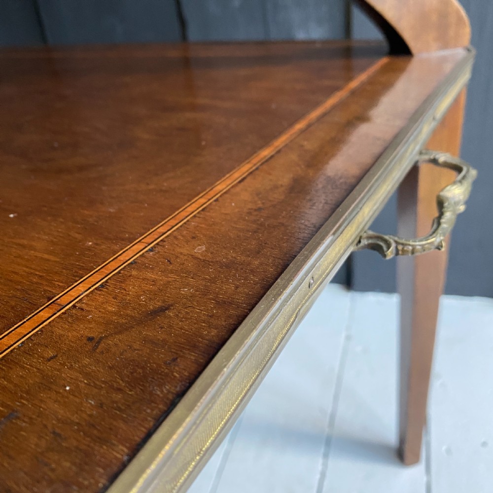 A two-tiered mahogany side table featuring a pink-veined marble top framed in brass, supported by curved legs over a lower wood shelf with brass side handles. View V