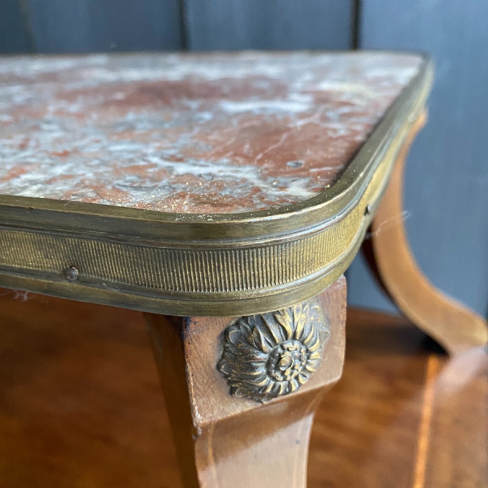 A two-tiered mahogany side table featuring a pink-veined marble top framed in brass, supported by curved legs over a lower wood shelf with brass side handles. View VII