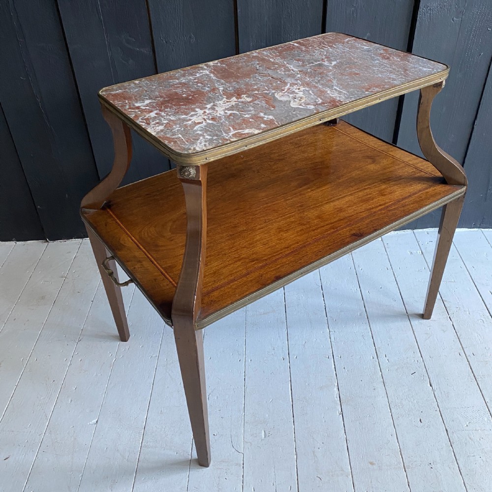 A two-tiered mahogany side table featuring a pink-veined marble top framed in brass, supported by curved legs over a lower wood shelf with brass side handles. View VIII