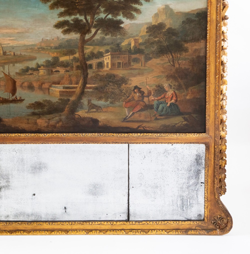 A large Georgian giltwood overmantel trumeau mirror featuring a classical oil painting of a landscape above three antiqued mirror plates. View V