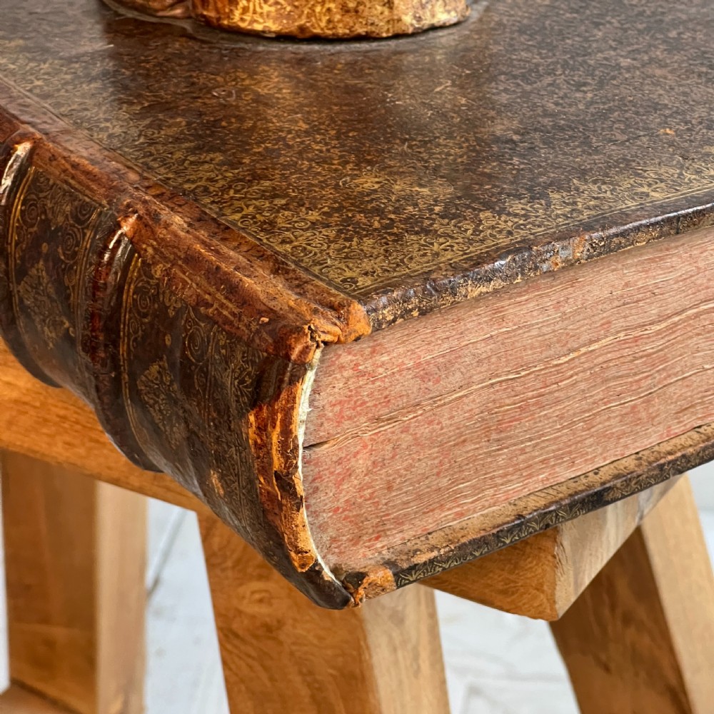 A table lamp featuring a column and base crafted from antique leather-bound book spines topped with a neutral drum shade. View V