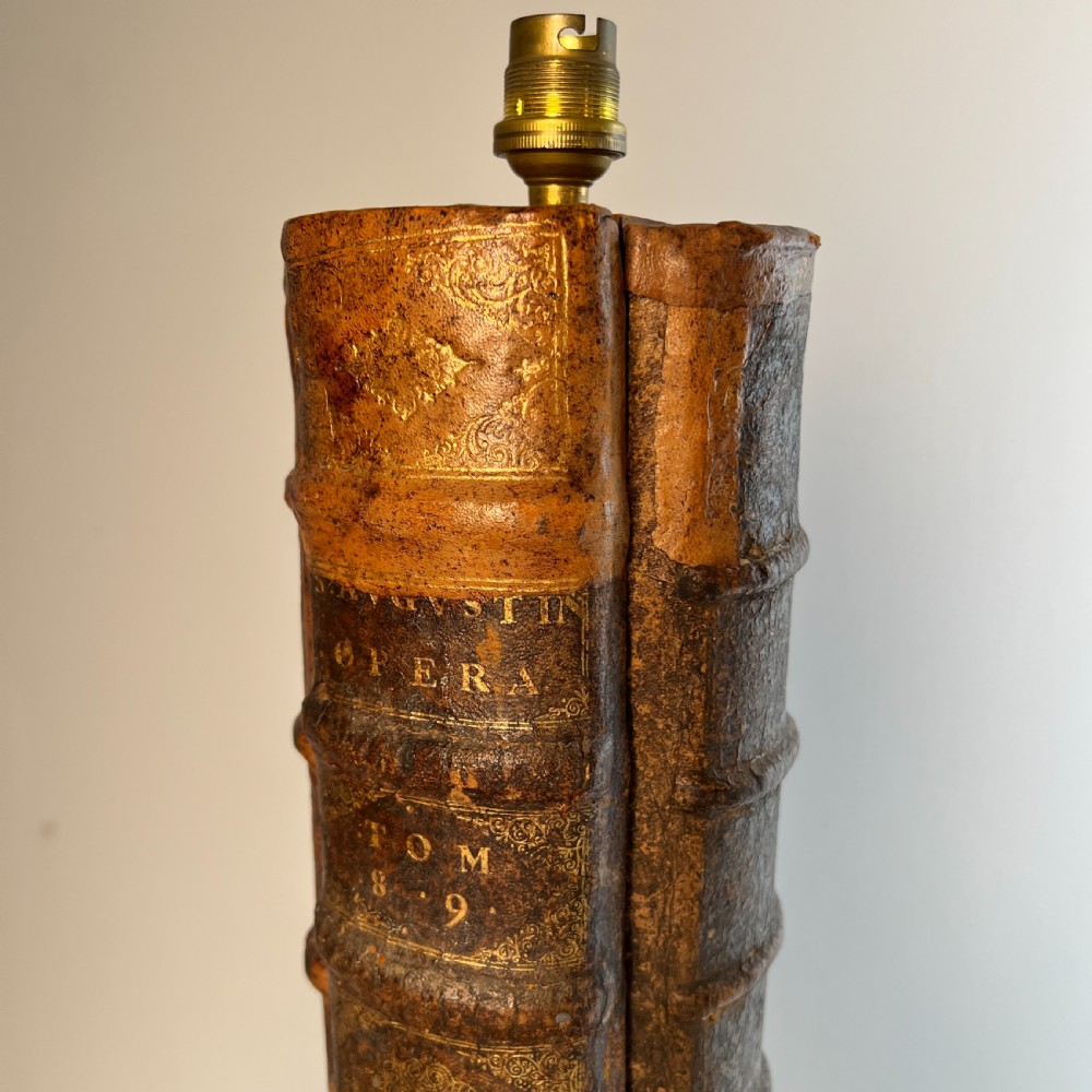 A table lamp featuring a column and base crafted from antique leather-bound book spines topped with a neutral drum shade. View VI