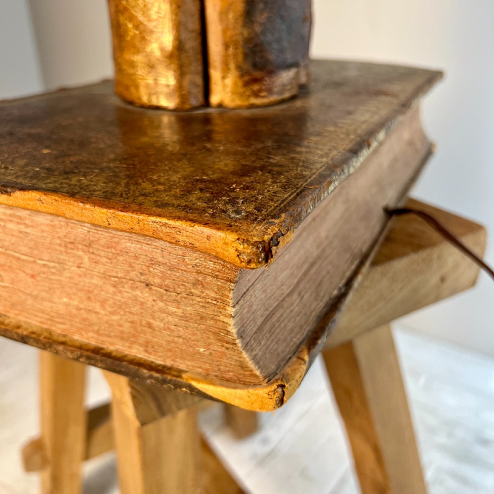 A table lamp featuring a column and base crafted from antique leather-bound book spines topped with a neutral drum shade. View VII