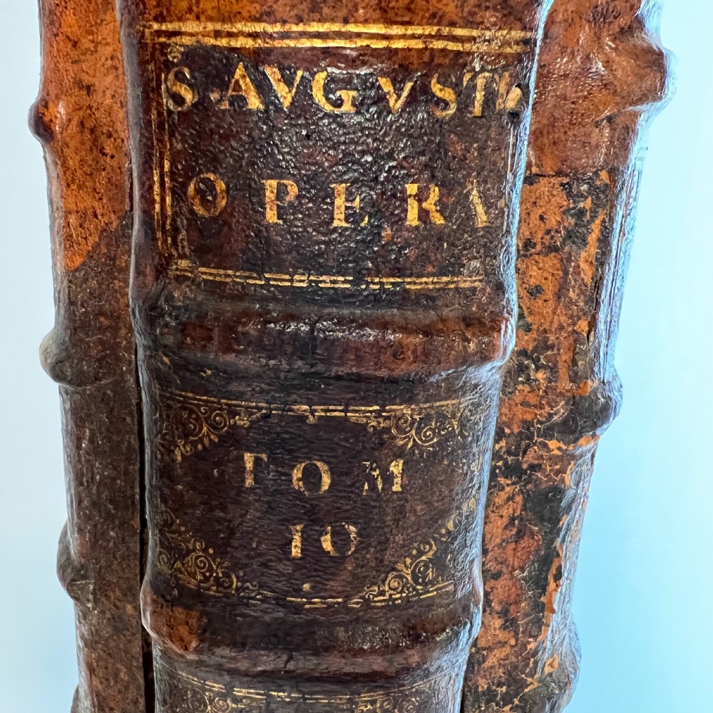 A table lamp featuring a column and base crafted from antique leather-bound book spines topped with a neutral drum shade. View VIII