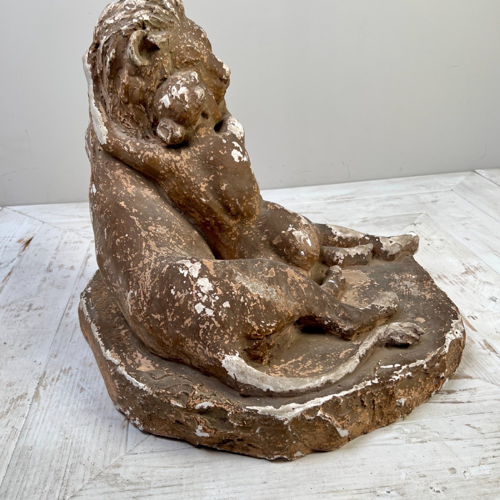 An antique brown terracotta and white painted plaster sculpture depicting a female figure embracing a lion on a naturalistic base. View VI