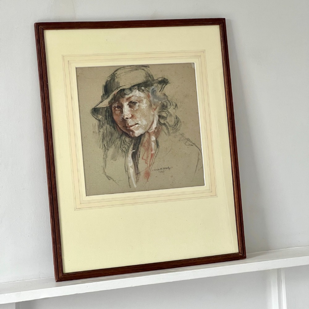 A framed original pastel drawing on grey paper depicting a figure in a hat, dated 1939, presented in a dark wood frame. View II