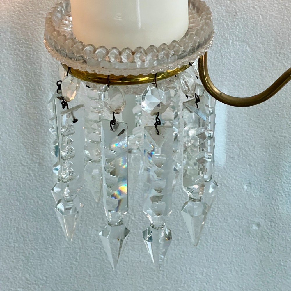 A pair of late Victorian two-light cut glass and brass Cricklite candelabra featuring suspended crystal prisms and clear glass pedestals. View IV