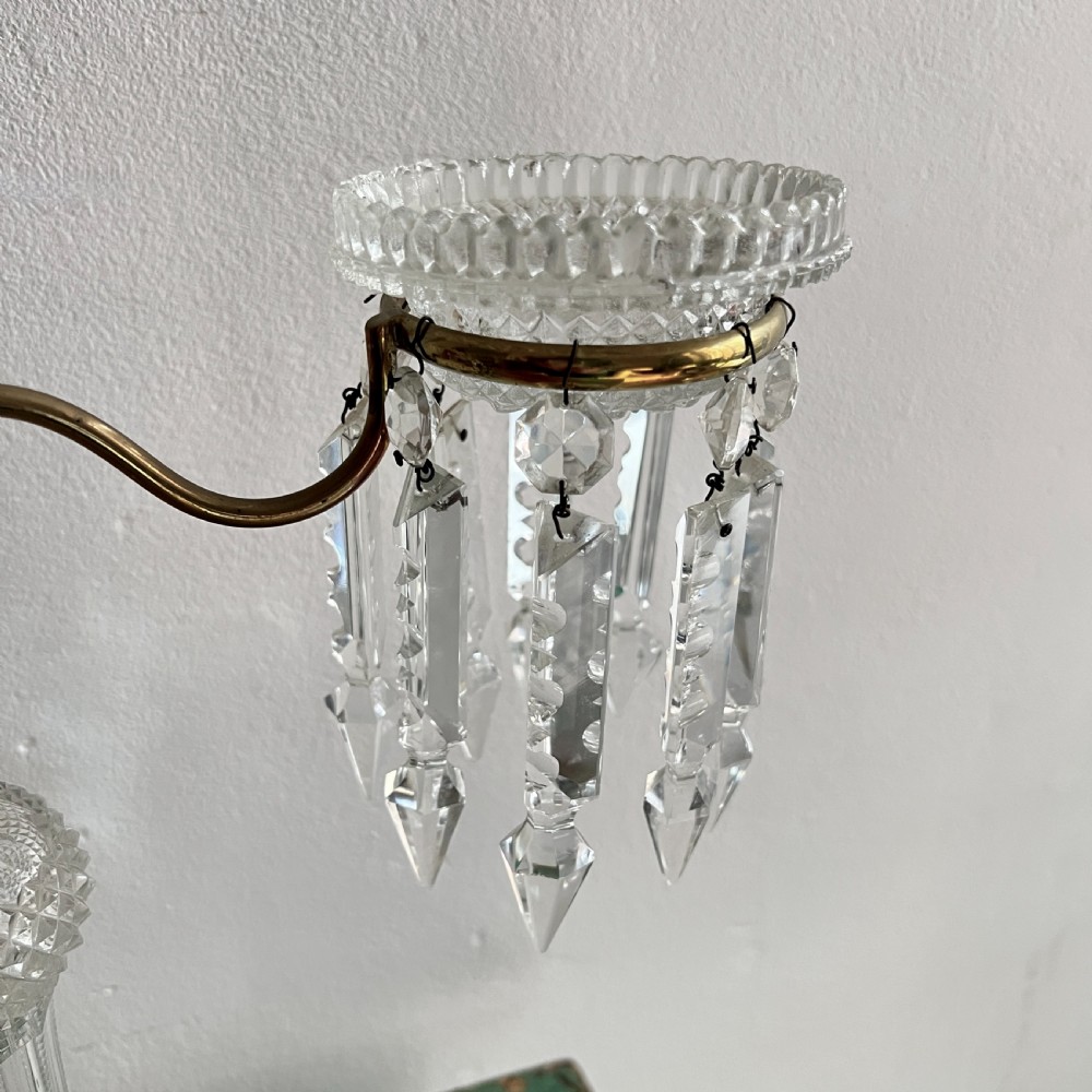 A pair of late Victorian two-light cut glass and brass Cricklite candelabra featuring suspended crystal prisms and clear glass pedestals. View VII