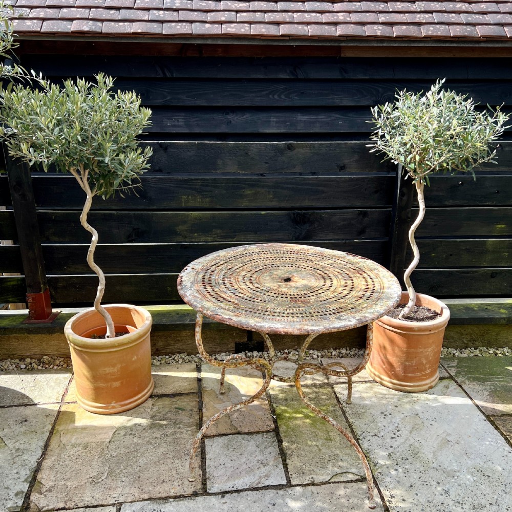 A circular French antique wrought iron garden table featuring a perforated metal top, curved legs with a central stretcher ring, and a heavily patinated weathered paint finish. View II