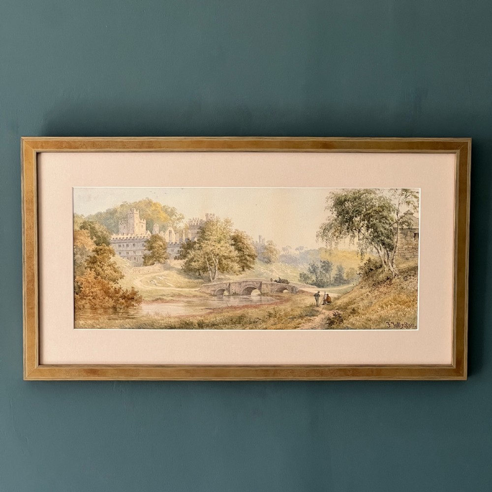A framed Victorian watercolour painting depicting Windsor Castle beyond a river and stone bridge, framed in a gold-toned wooden frame with a cream mount. View II