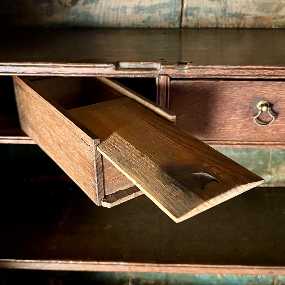 A large Georgian oak breakfront housekeepers cupboard featuring twin side cabinets with drawers, central open shelves, and brass swan-neck handles. View X