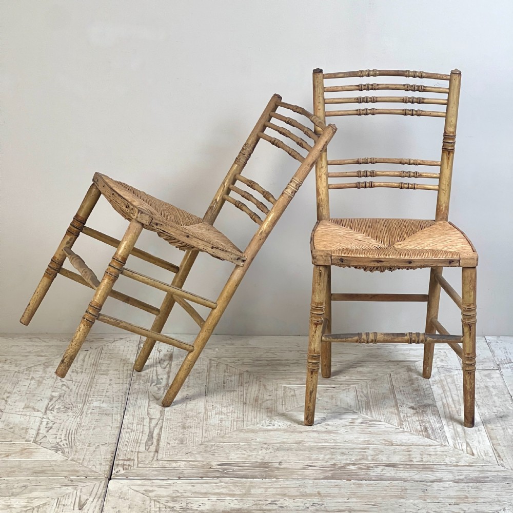 A pair of antique Regency side chairs featuring painted faux bamboo turned frames and woven rush seats. View III