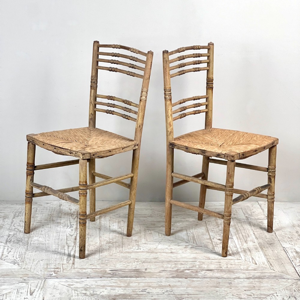 A pair of antique Regency side chairs featuring painted faux bamboo turned frames and woven rush seats. View VII