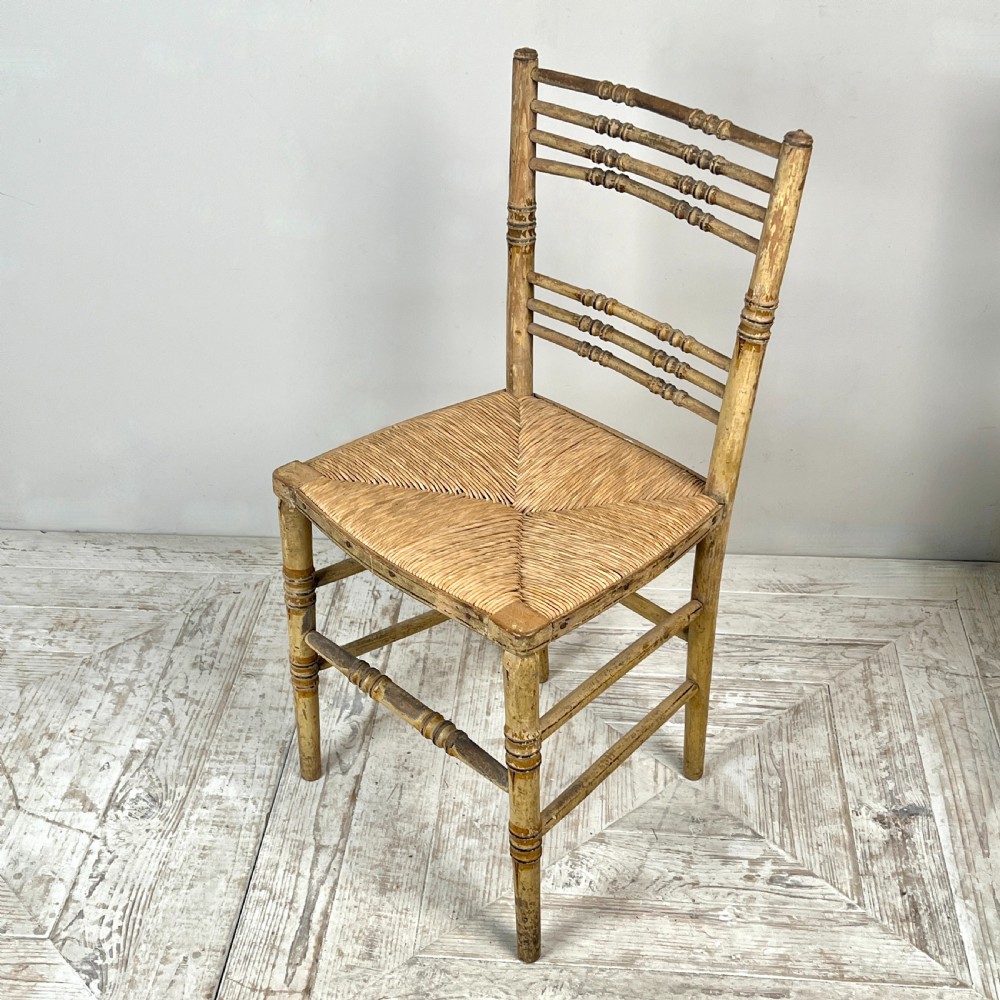 A pair of antique Regency side chairs featuring painted faux bamboo turned frames and woven rush seats. View VIII