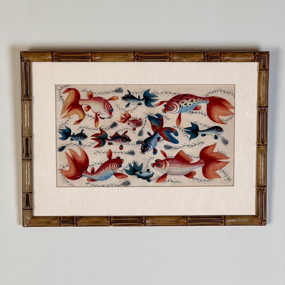 A late 19th-century Chinese gouache painting on pith paper depicting red and blue goldfish swimming among aquatic foliage, presented in a bamboo-style frame with a light mount.