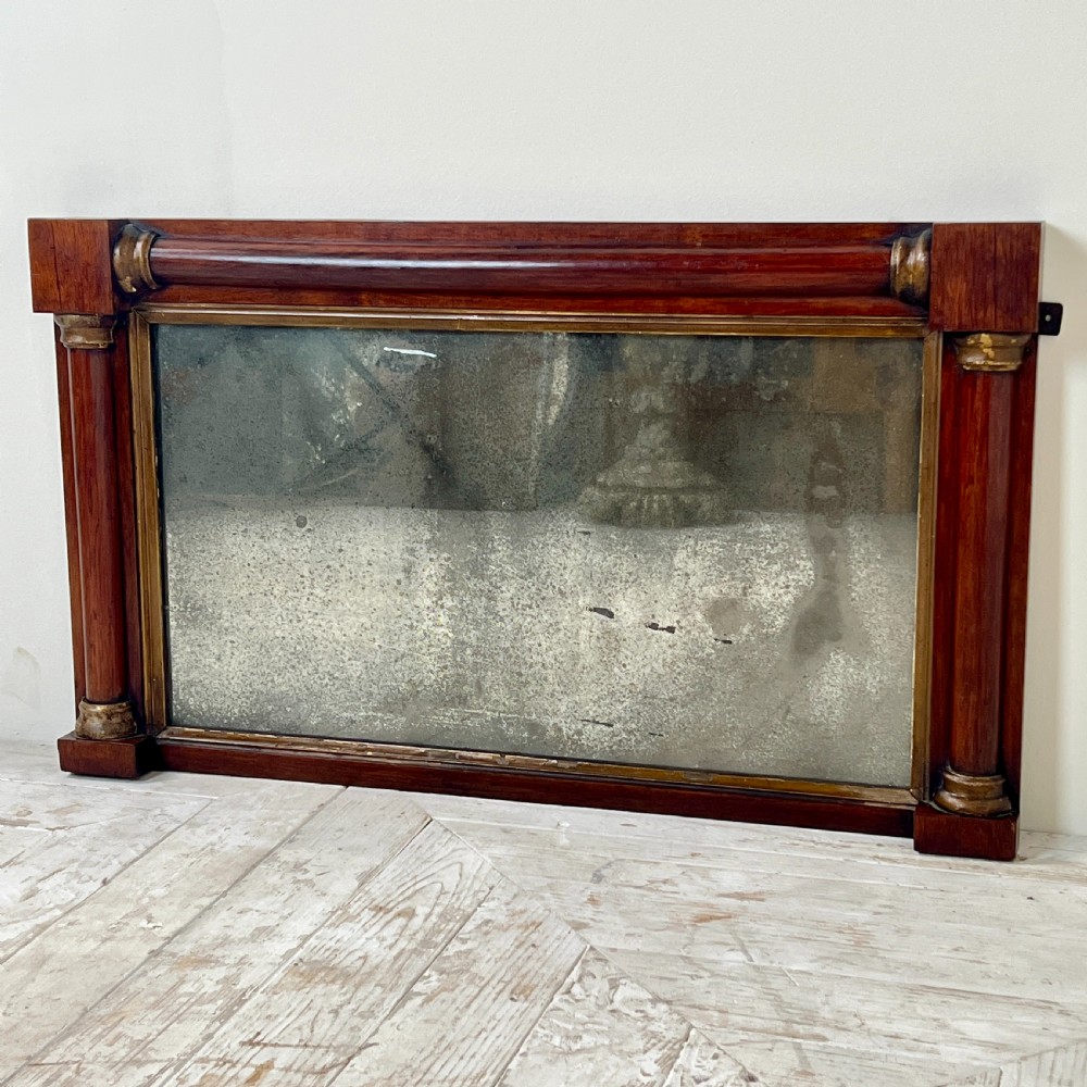 An early 19th-century horizontal mahogany overmantel mirror featuring turned side pilasters, gilt accents, and foxed glass. View VII