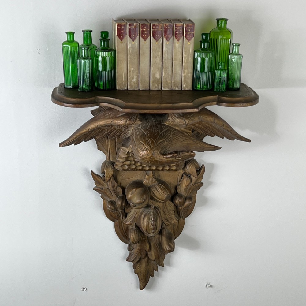 A 19th-century carved giltwood wall bracket featuring a spread-winged eagle above carved fruit and acanthus leaf details. View III