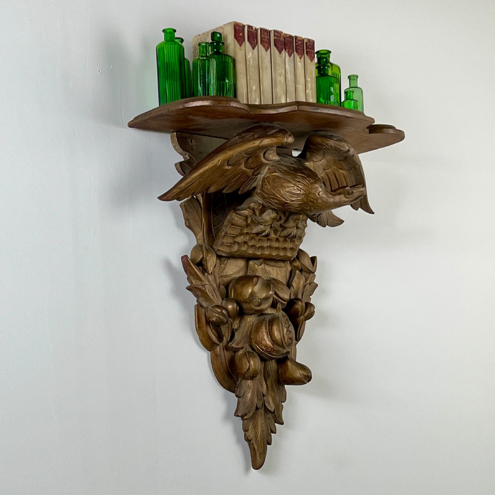 A 19th-century carved giltwood wall bracket featuring a spread-winged eagle above carved fruit and acanthus leaf details. View IV