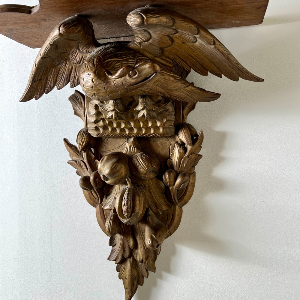 A 19th-century carved giltwood wall bracket featuring a spread-winged eagle above carved fruit and acanthus leaf details. View VII