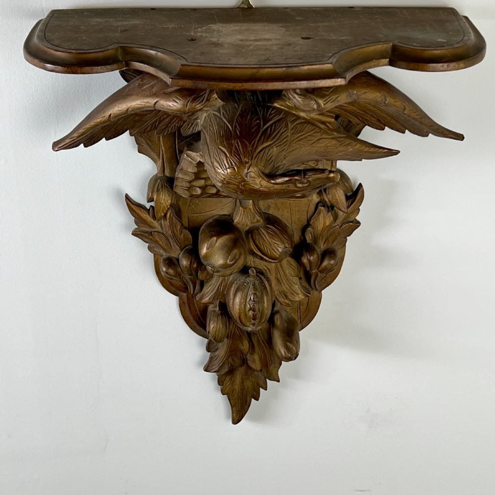 A 19th-century carved giltwood wall bracket featuring a spread-winged eagle above carved fruit and acanthus leaf details. View VIII