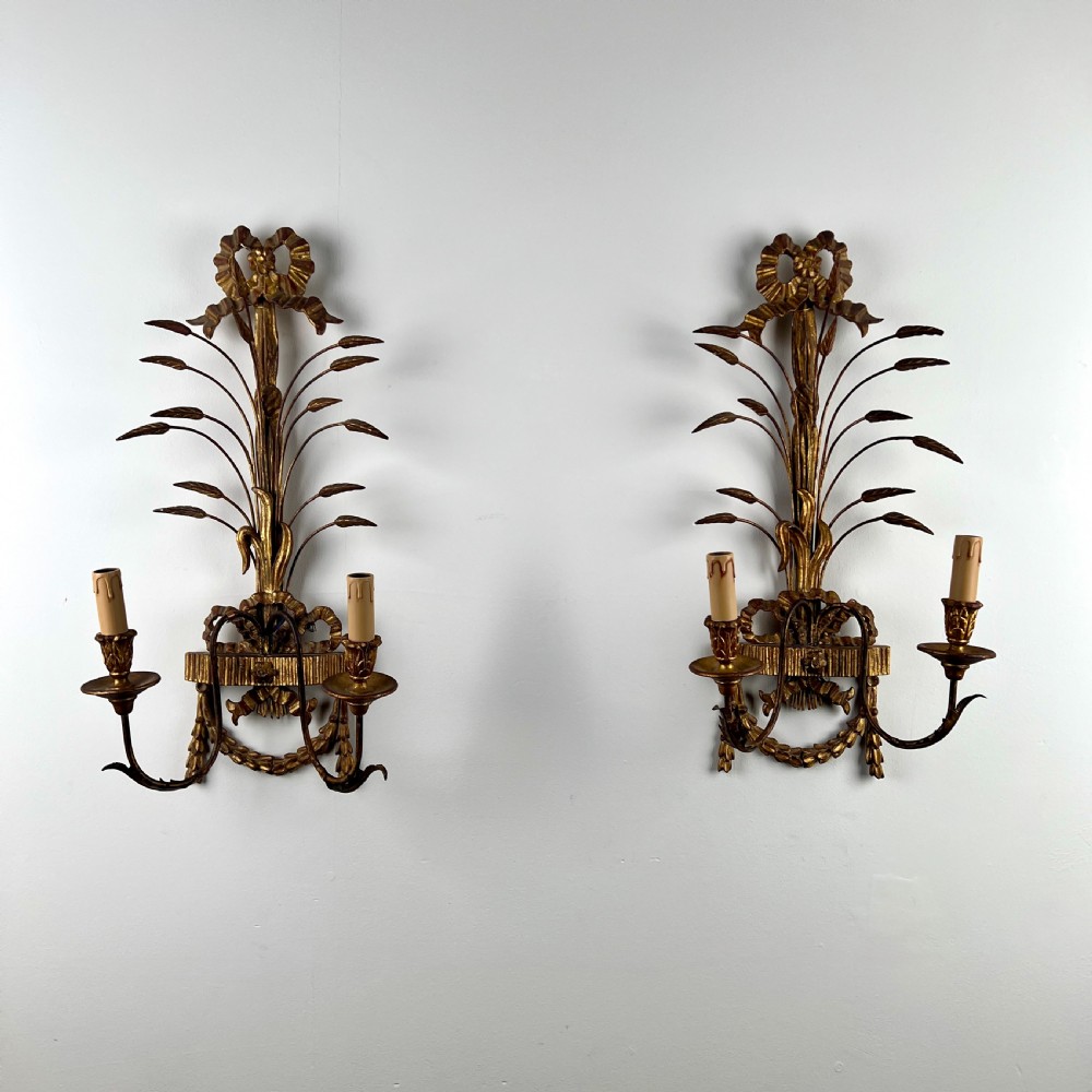 A pair of early 20th-century Italian giltwood and toleware wall sconces featuring carved ribbon bow crests, rising foliage sprigs, and twin candle arms. View II