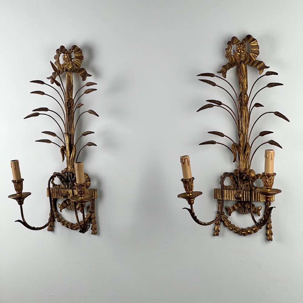 A pair of early 20th-century Italian giltwood and toleware wall sconces featuring carved ribbon bow crests, rising foliage sprigs, and twin candle arms. View III