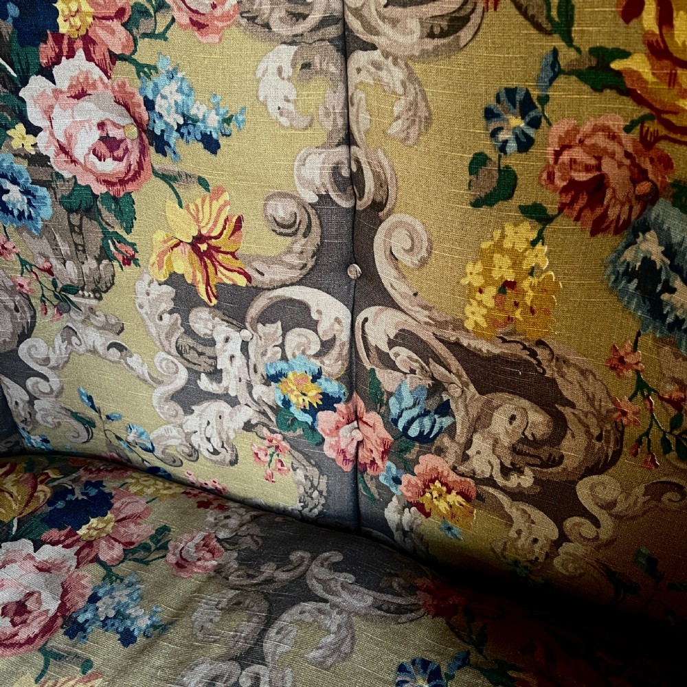 A high-backed woven wicker porters chair featuring a hooded canopy and floral upholstered linen interior. View XI