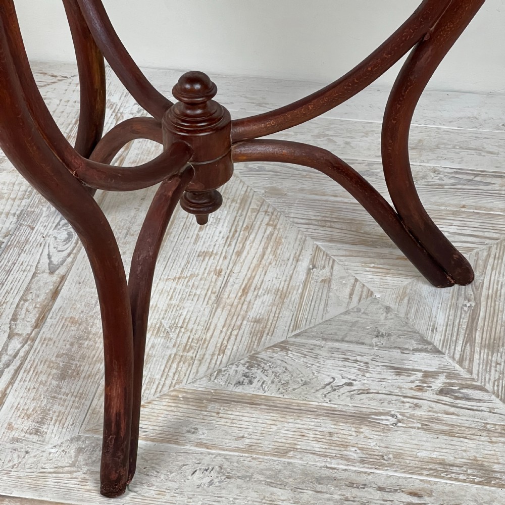 A triangular bentwood card table featuring a green felt playing surface, three curved legs, and a central turned wooden finial. View III