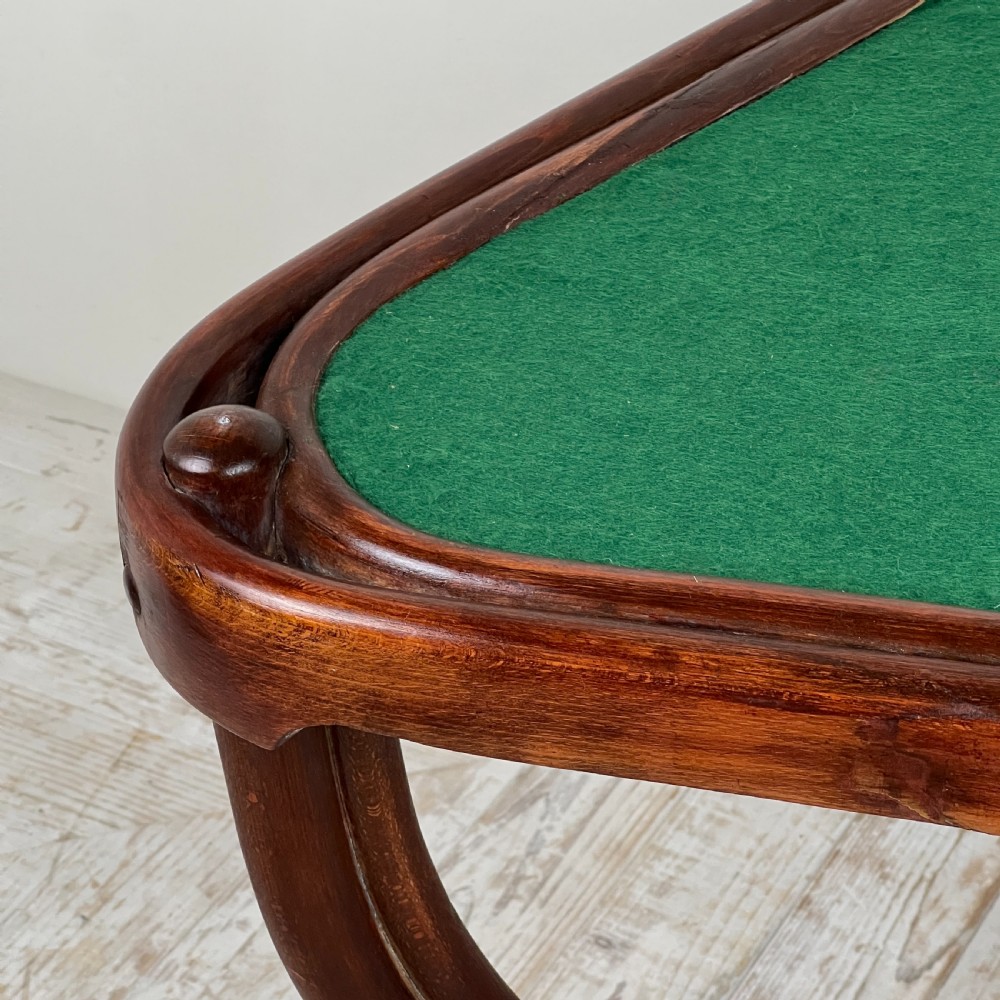 A triangular bentwood card table featuring a green felt playing surface, three curved legs, and a central turned wooden finial. View IV