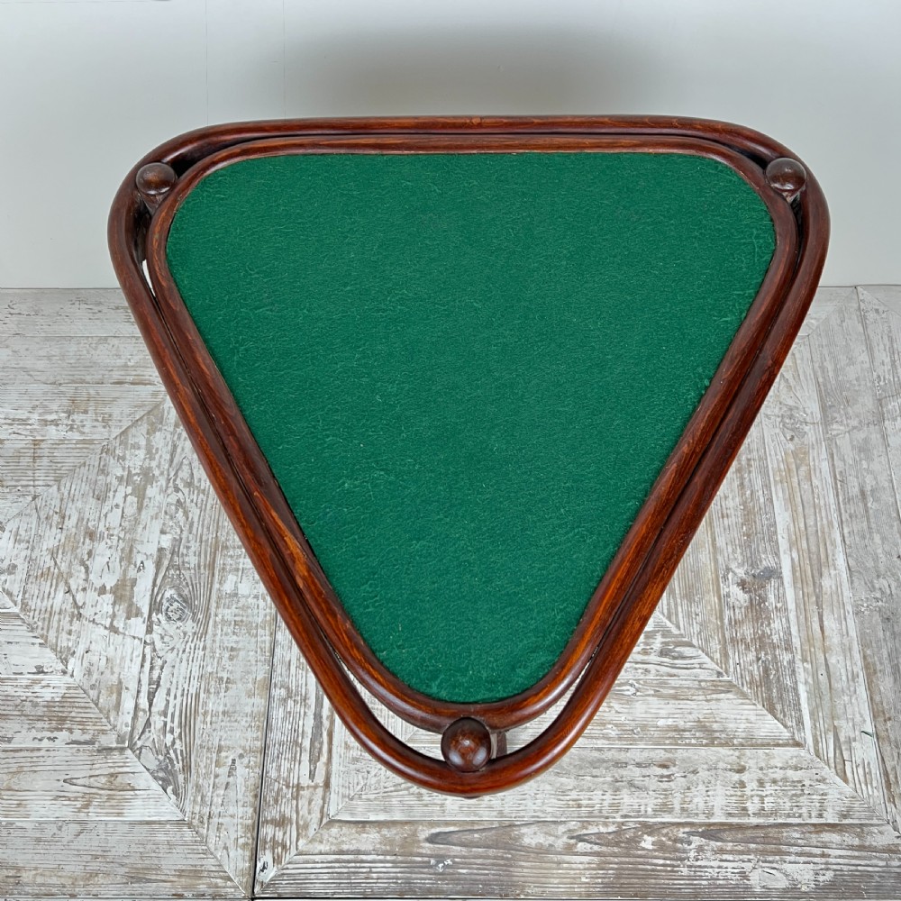 A triangular bentwood card table featuring a green felt playing surface, three curved legs, and a central turned wooden finial. View VI