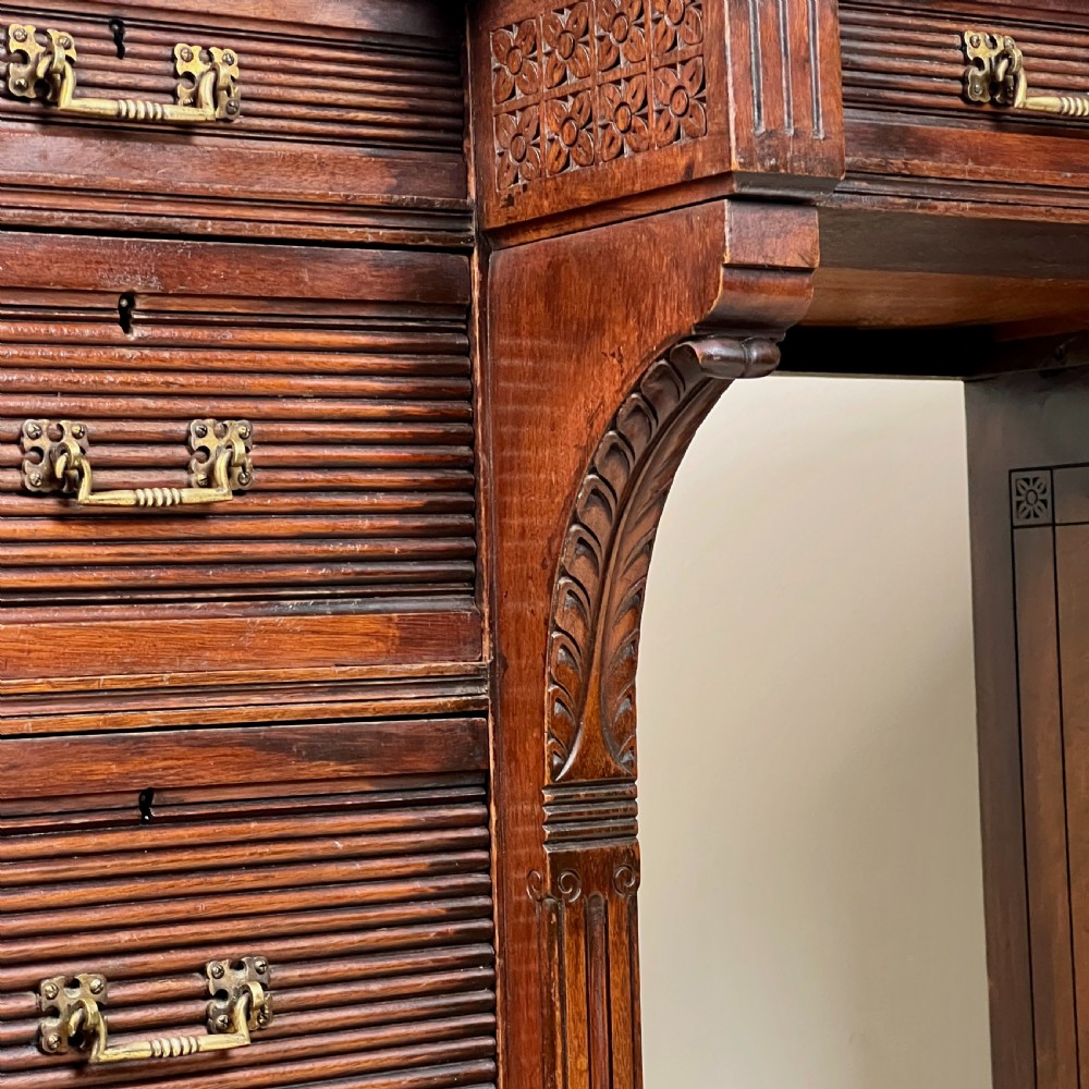 A Victorian mahogany breakfront pedestal desk featuring a green leather inset writing surface with gold tooling and multiple drawers with brass handles. View X