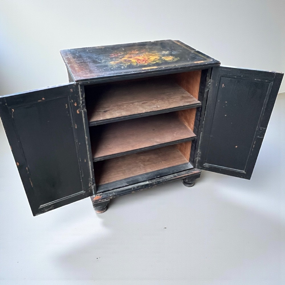 A Victorian ebonised black pine cabinet featuring two panelled doors decorated with hand-painted floral bouquets. View II