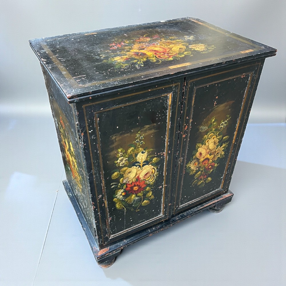 A Victorian ebonised black pine cabinet featuring two panelled doors decorated with hand-painted floral bouquets. View IV