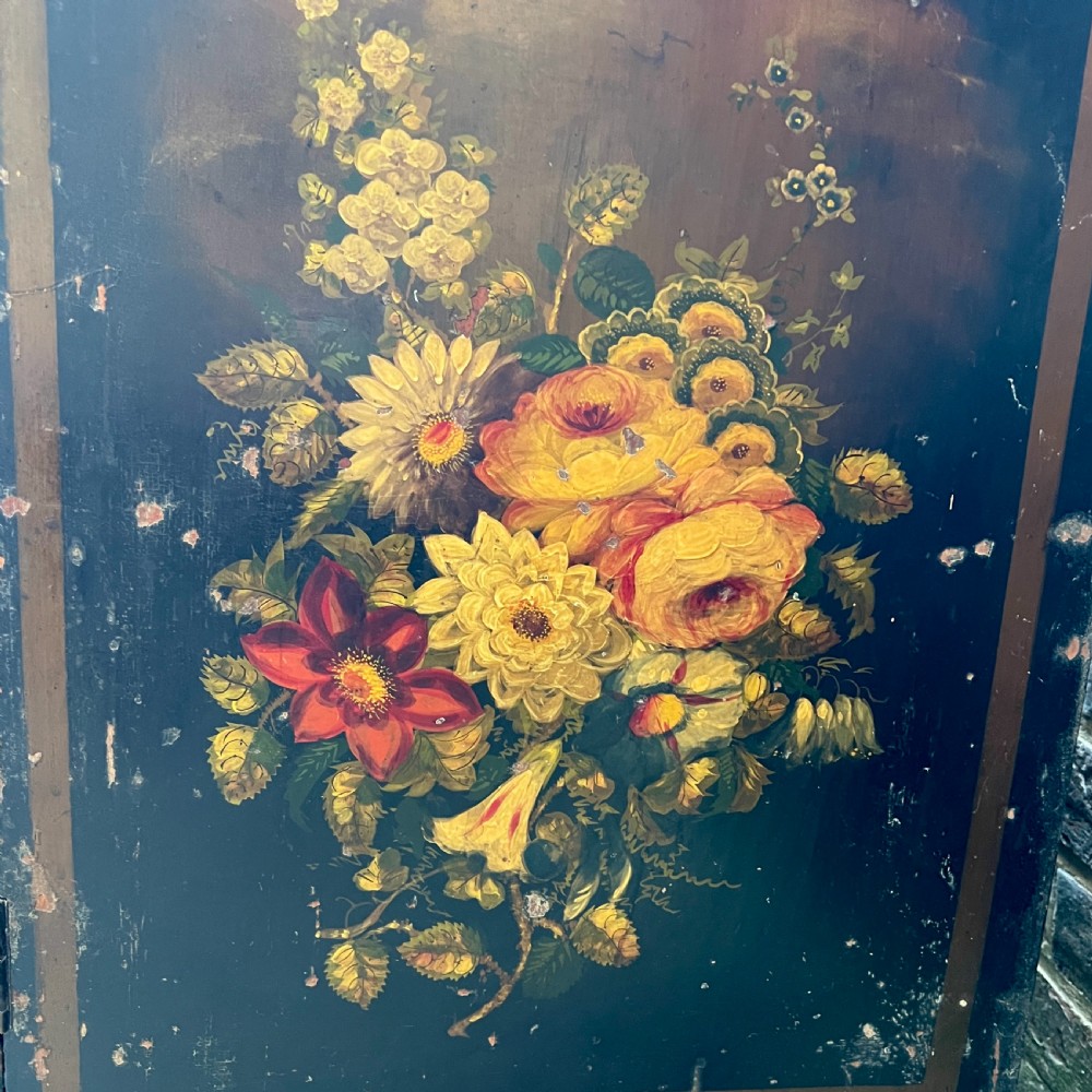 A Victorian ebonised black pine cabinet featuring two panelled doors decorated with hand-painted floral bouquets. View V