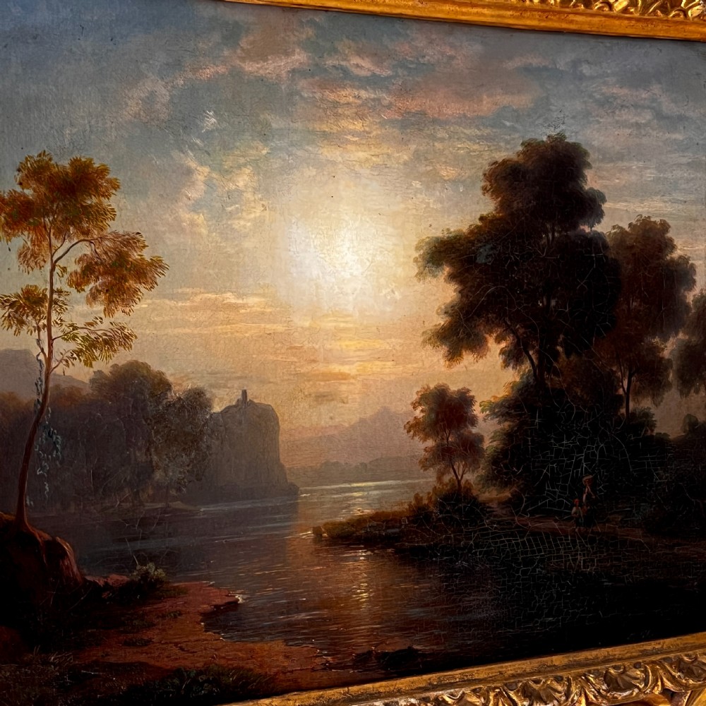 An antique oil painting on canvas depicting a tranquil riverscape framed by dense trees and a soft sky, enclosed within an ornate carved giltwood frame. View III