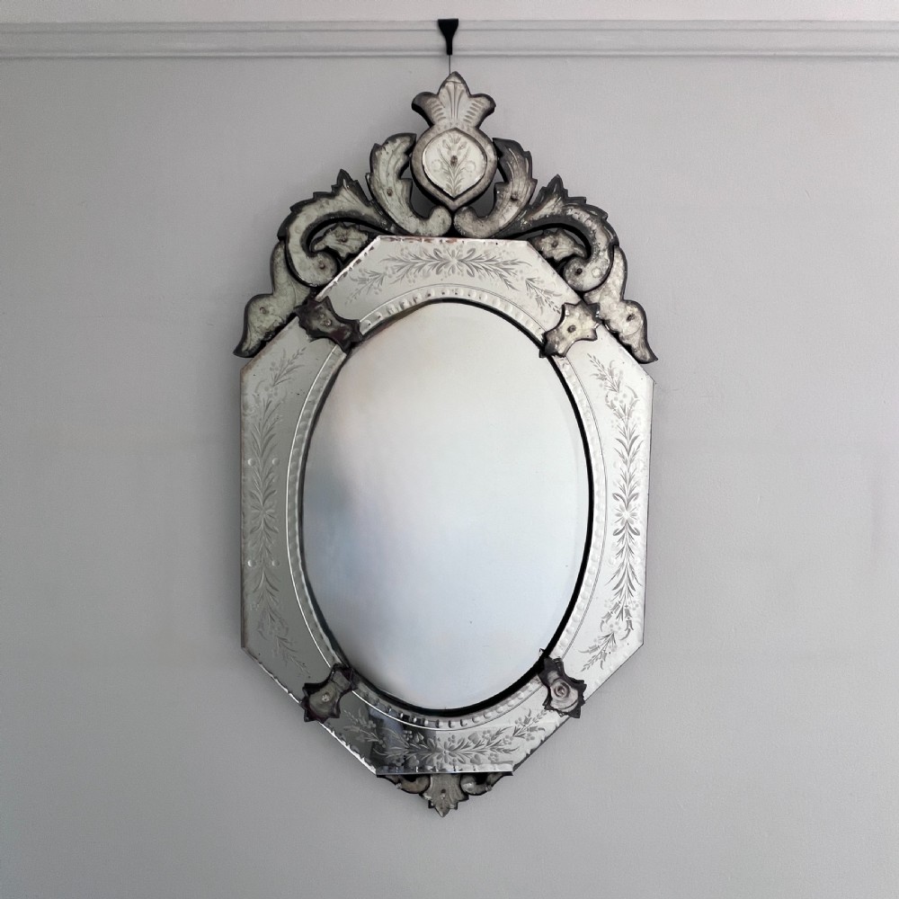 An octagonal Venetian-style wall mirror featuring etched floral borders, an oval central plate, and a decorative scrolling glass crest. View II