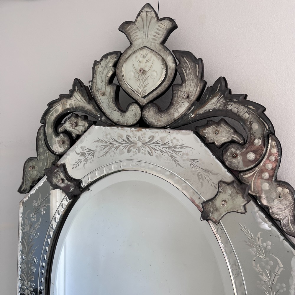 An octagonal Venetian-style wall mirror featuring etched floral borders, an oval central plate, and a decorative scrolling glass crest. View VIII