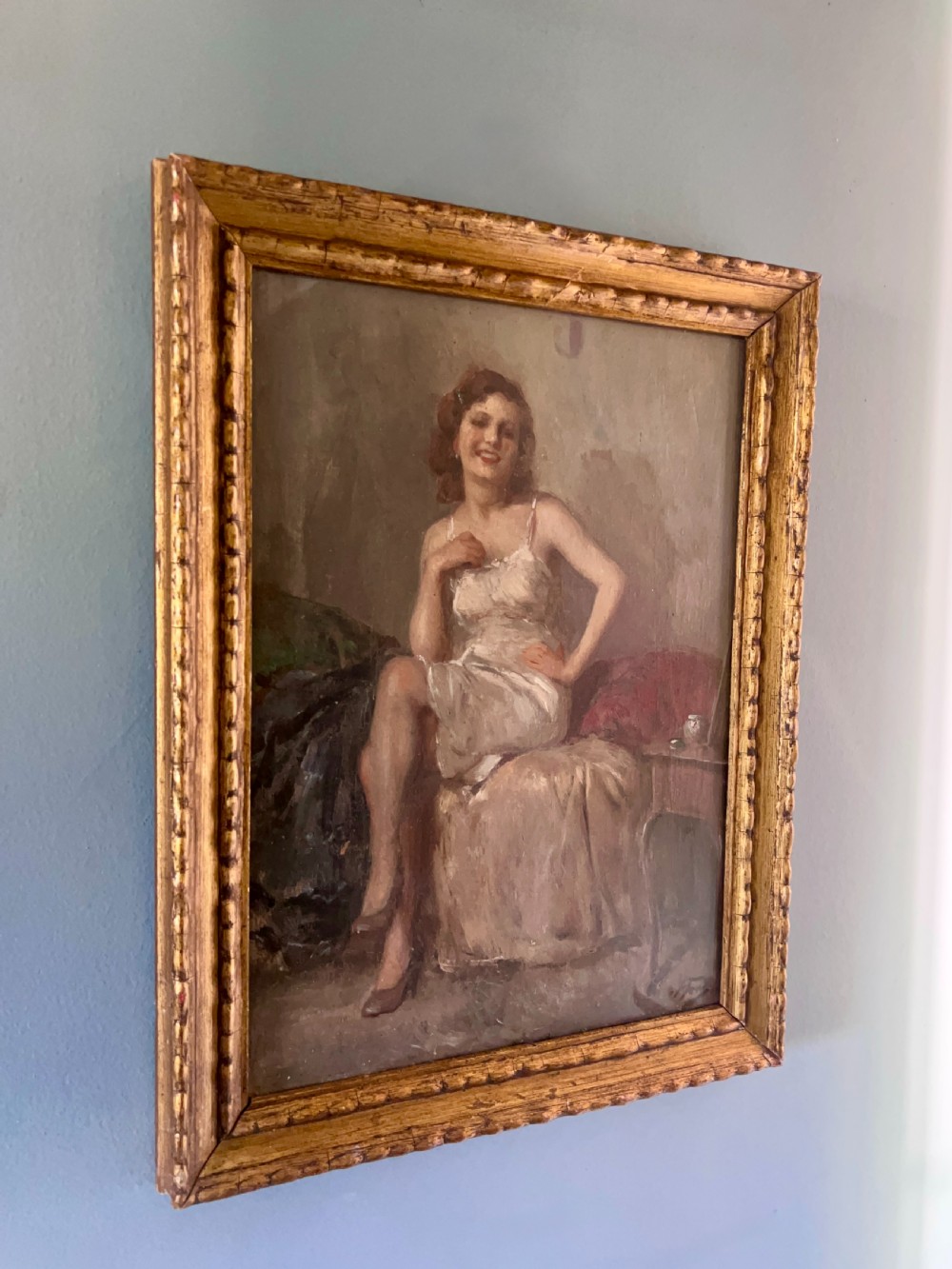 An oil painting depicting a seated woman in a light dress contained within an ornate gilt wooden frame. View III