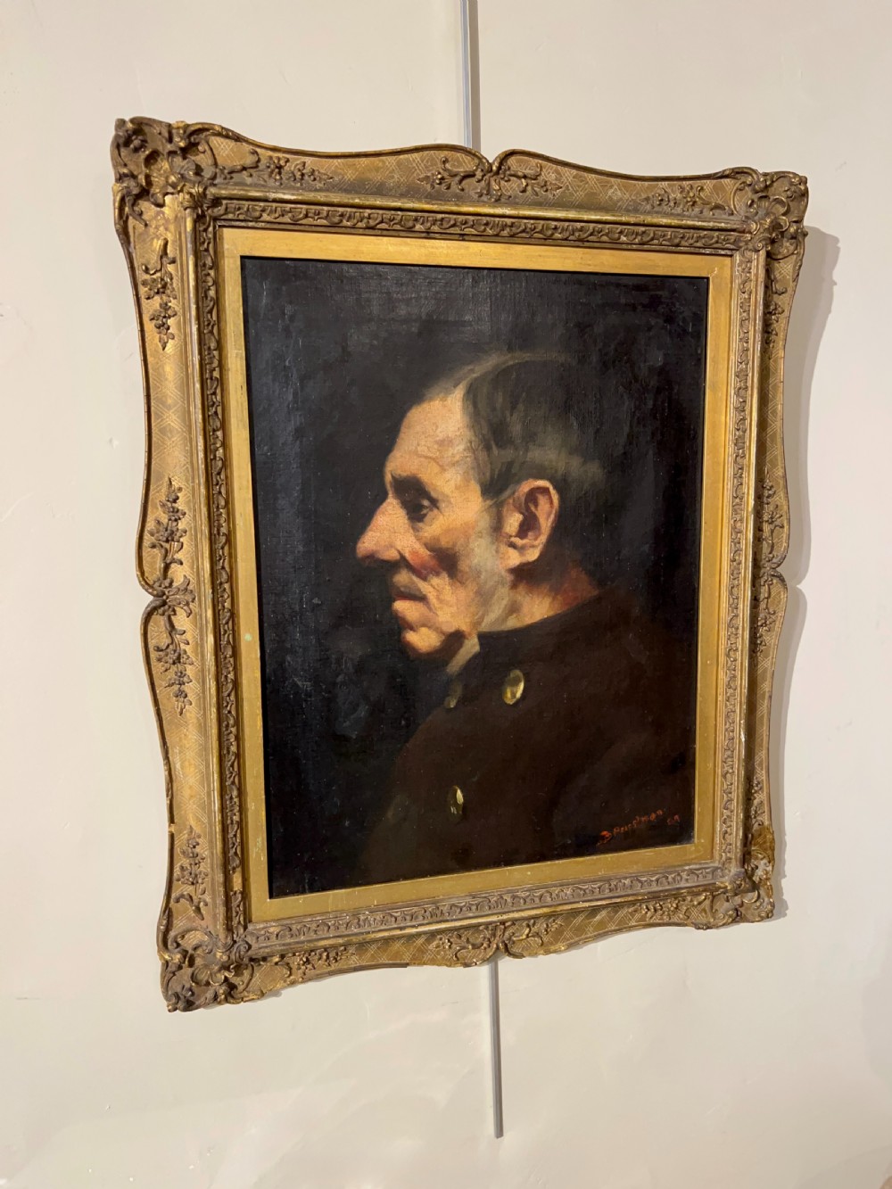 A side-profile oil portrait painting of a gentleman set within an ornate carved gilded wooden frame. View III