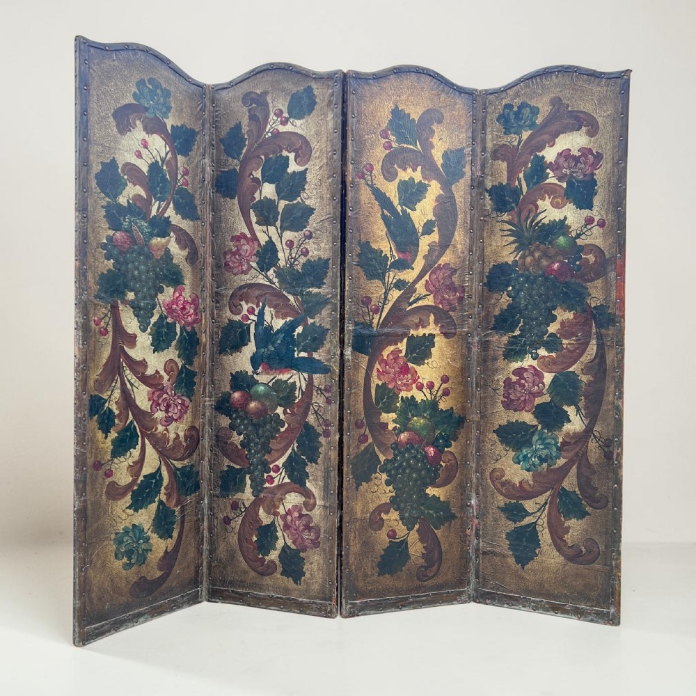 A four-panel French room divider screen made of gilt leather hand-painted with green foliage, floral scrolls, and birds, bordered with brass studding.