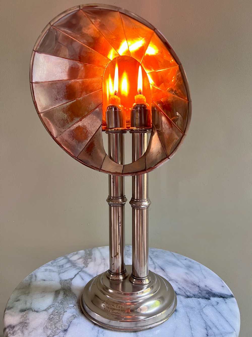 An Edwardian silver-plated candle lamp featuring twin column stems, a curved segmented reflector hood, and an engraved circular base. View II