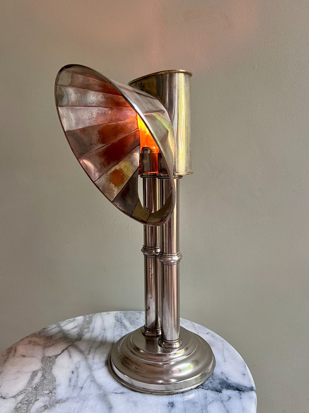 An Edwardian silver-plated candle lamp featuring twin column stems, a curved segmented reflector hood, and an engraved circular base. View IX