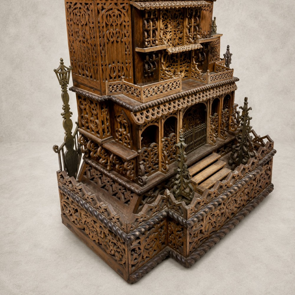 A carved wooden clock case designed in a Gothic cathedral architectural style with detailed fretwork, three spires, and a circular central opening. View III